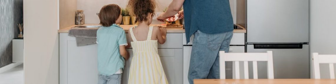 Father and children cooking together in a modern kitchen, enjoying family time.